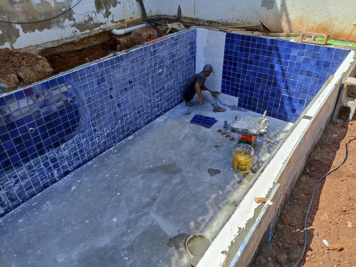 Aplicação do revestimento azul na piscina